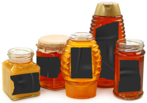 honey jars with labels blacked out with tape
